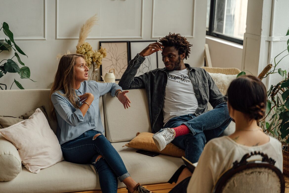 Couple sitting together, facing away from each other, with a therapist mediating. Couple sitting together, facing away from each other, with a therapist mediating.